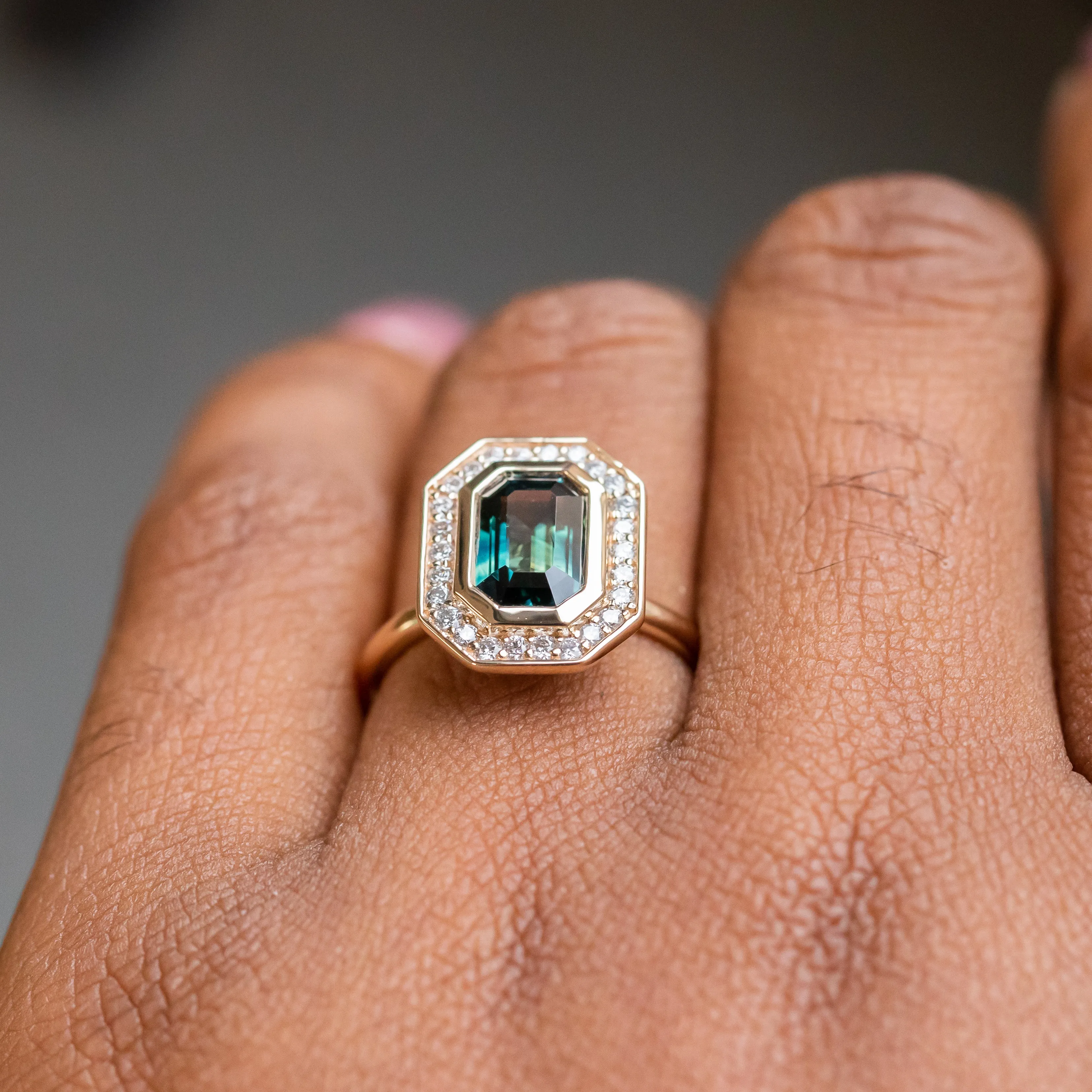 2.05ct Emerald cut Sapphire With Bezel Set Diamond Halo In 14k Yellow Gold