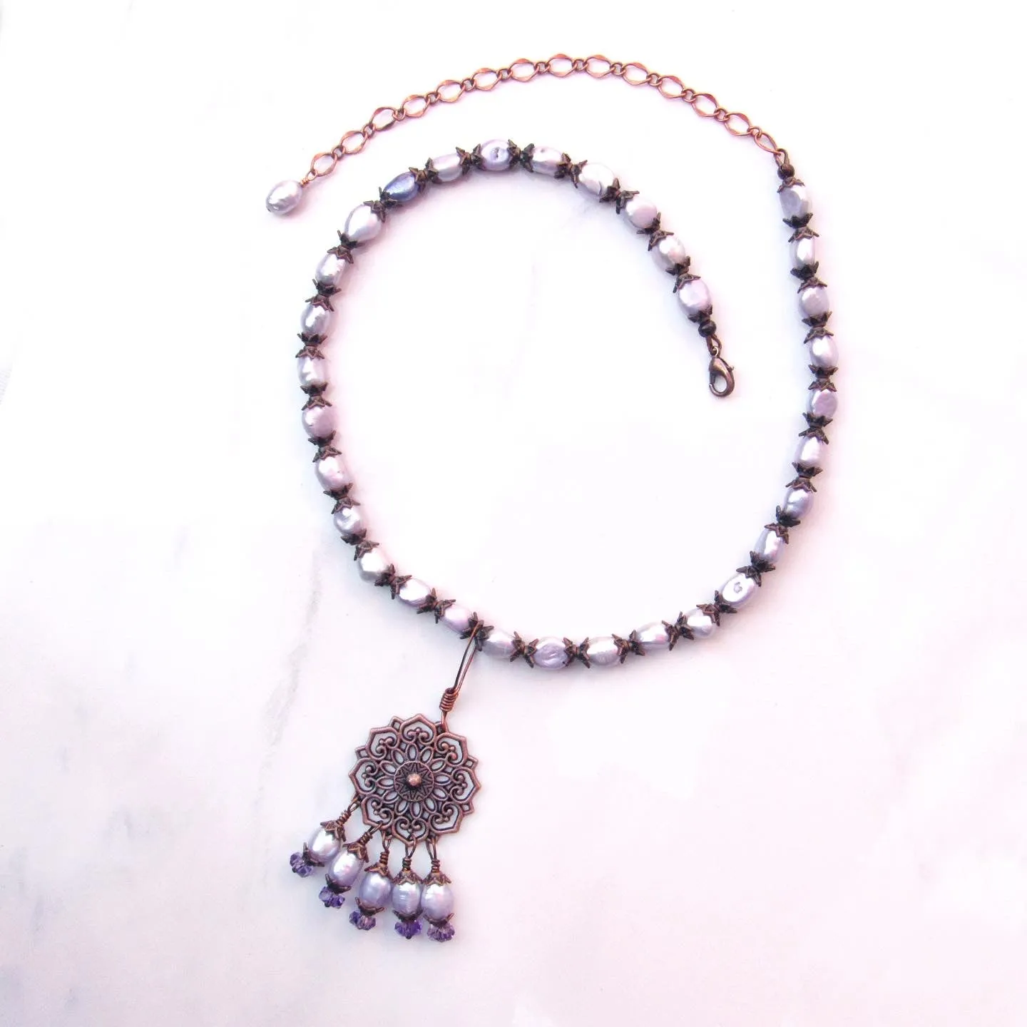 Purple freshwater pearls, amethyst gemstones, and copper chain and pendant design.